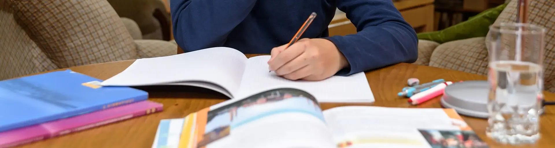 Student sitting at a table at home completing schoolwork